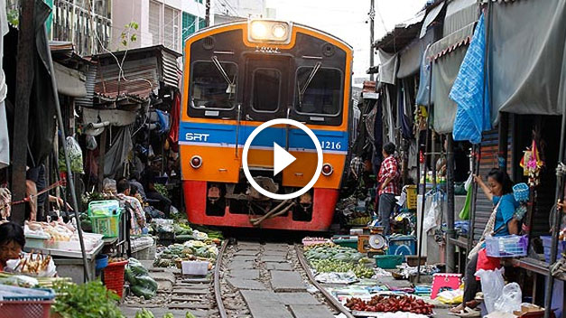 unbelievable train runs trough vegetable market in thailand