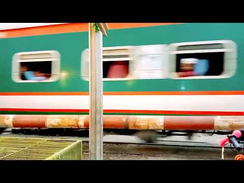 Train passing through a busy rail crossing place with Bangladesh raiway.